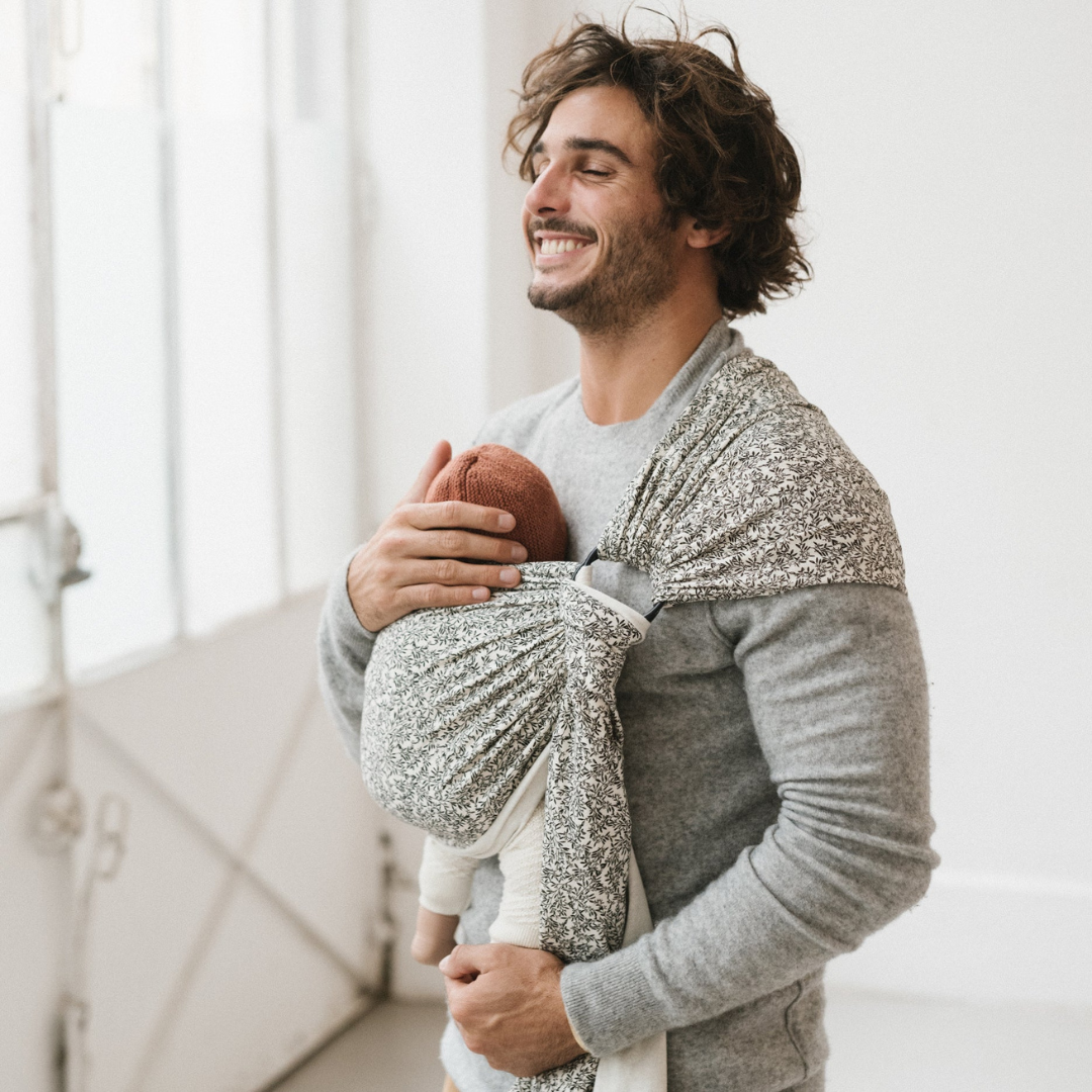Papa en congé paternité portant son enfant