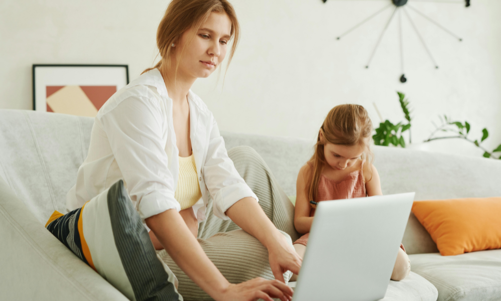 Femme enceinte qui travaille à la maison devant son ordinateur