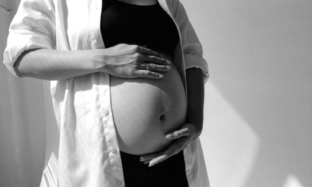 Femme enceinte qui se tient le ventre car elle est inquiète