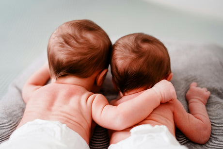 bébés jumeaux qui se tiennent l'un à l'autre par l'épaule